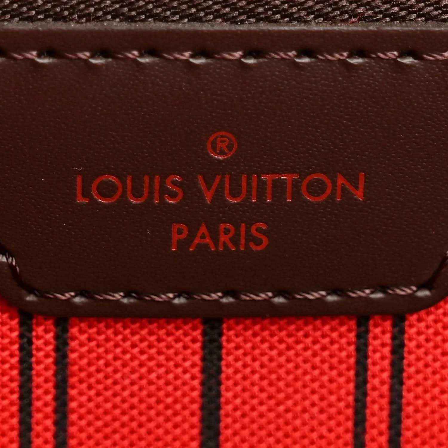 Louis Vuitton Paris leather label on red-lined tote interior with stitched border