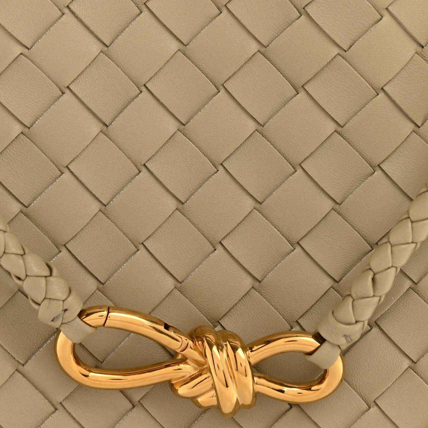 Bottega Veneta woven leather bag panel with gold-tone knot clasp on travertine