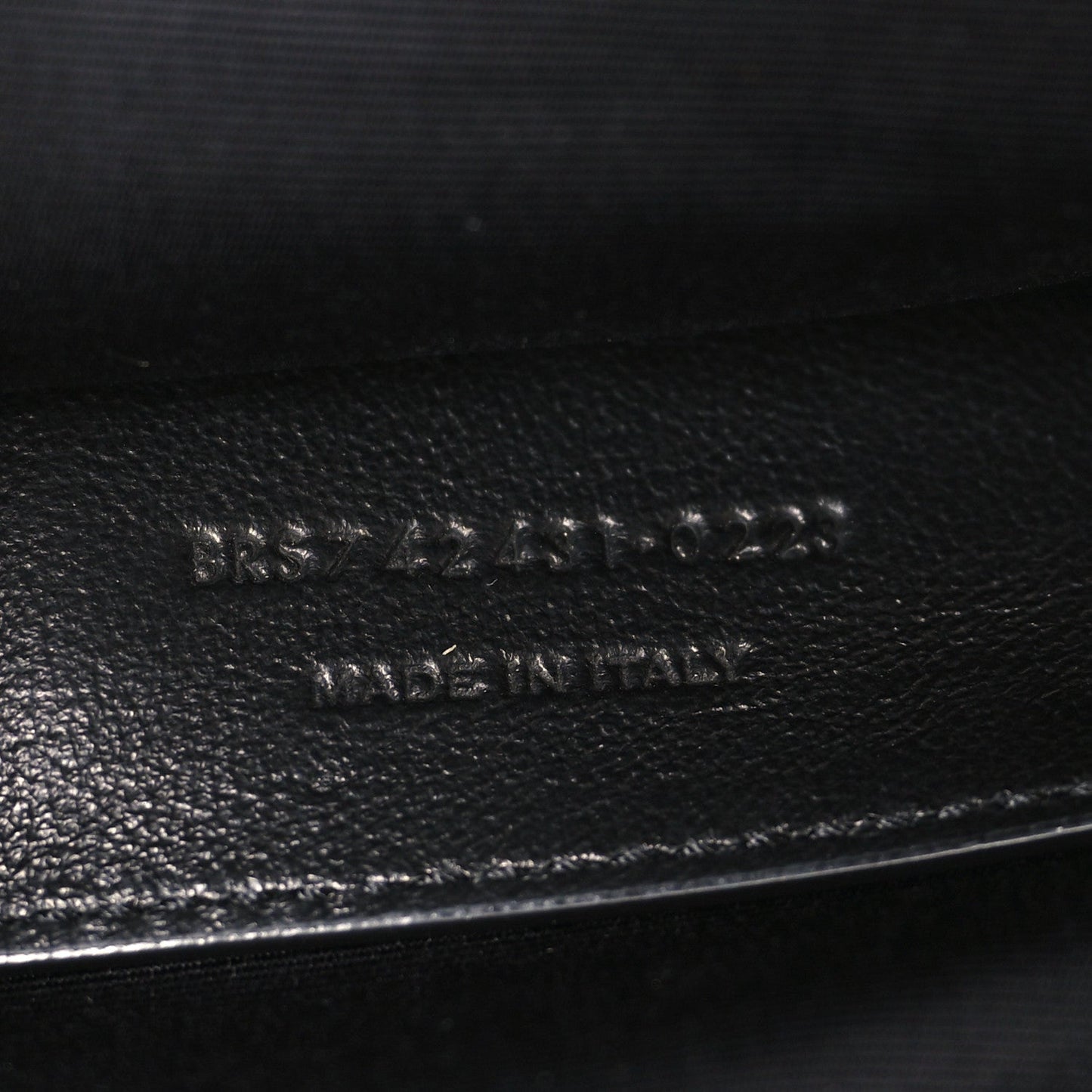 Leather brand stamp on black lambskin interior panel near zipper