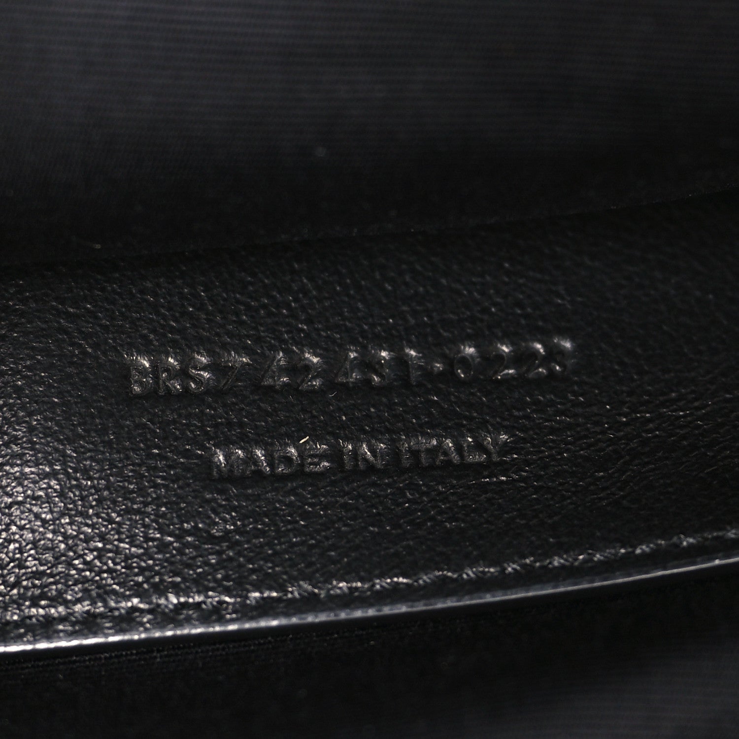 Leather brand stamp on black lambskin interior panel near zipper