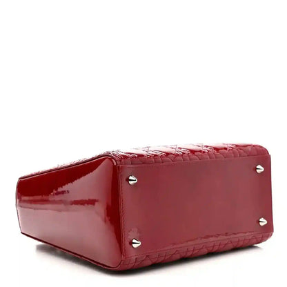 Red patent leather handbag base with small metal studs and glossy finish.
