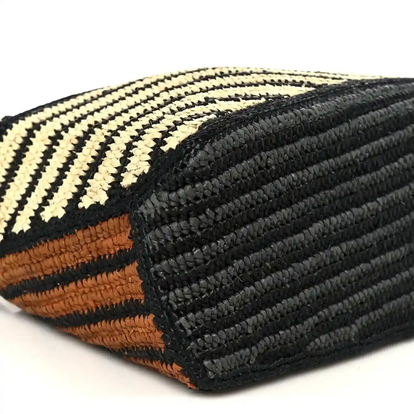 Small raffia puzzle bag corner detail with black textured panel and striped weave