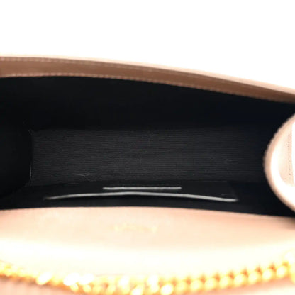 Dark beige satchel interior with black lining and gold chain edge