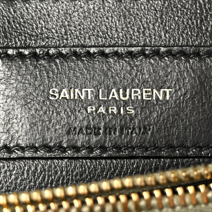 Black leather label on bag interior with “SAINT LAURENT PARIS” text and stitching
