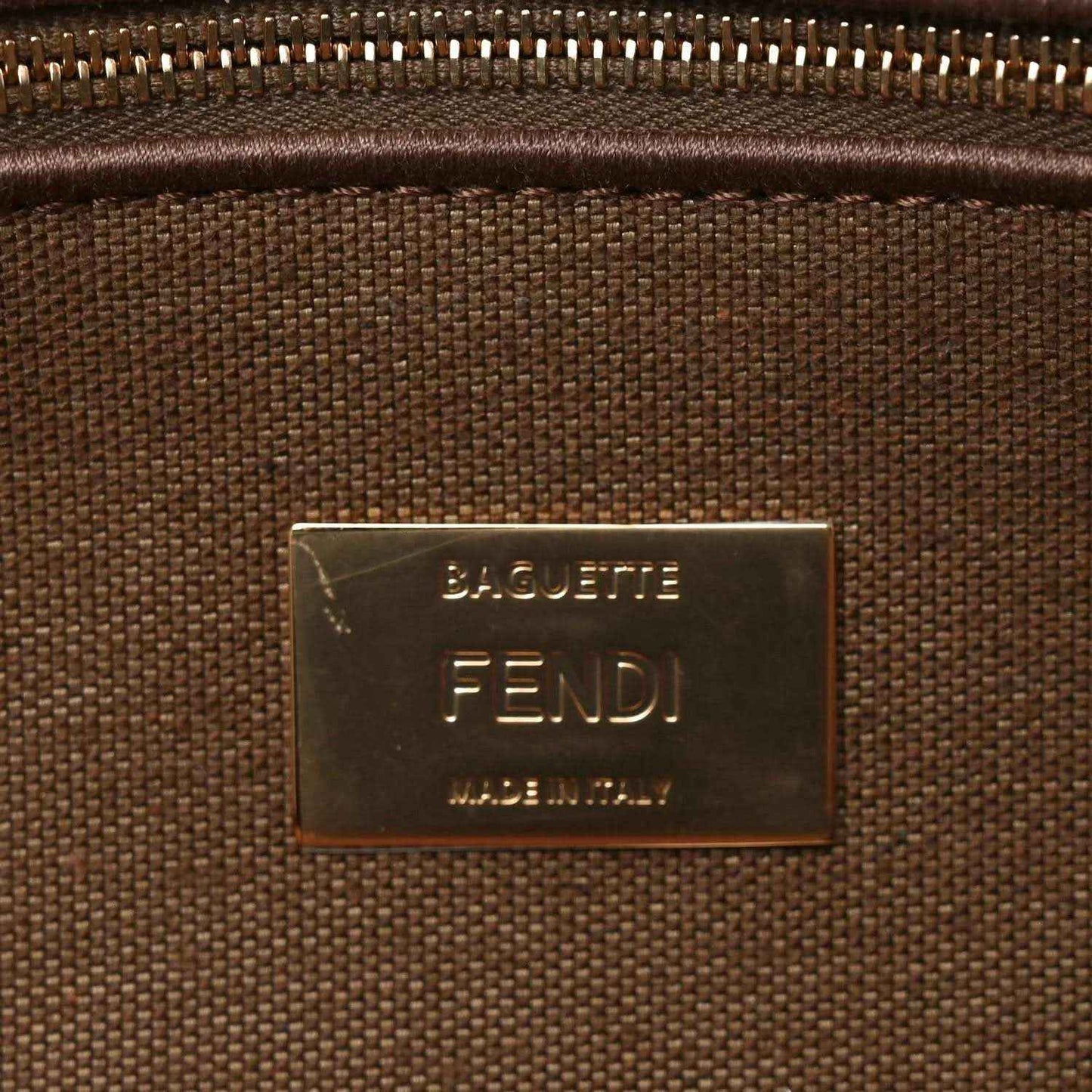 Gold-tone Fendi Baguette logo plaque on a brown interior fabric lining