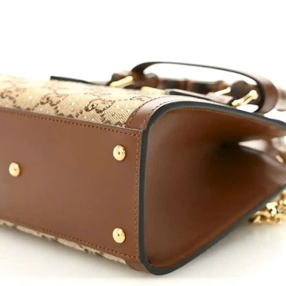 Mini tote bag side opening view with brown interior and gold-tone chain strap