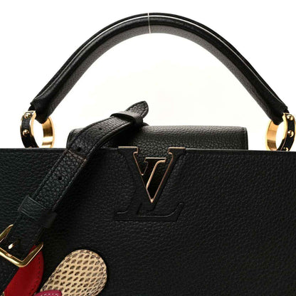 Louis Vuitton Capucines BB bag close-up of black leather handles with LV emblem