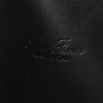 Close-up of black ostrich-textured leather pouch surface with subtle stitching