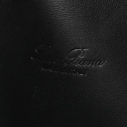 Close-up of black ostrich-textured leather pouch surface with subtle stitching