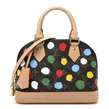 Small handbag with black canvas, multicolor dot print, tan leather top handles.