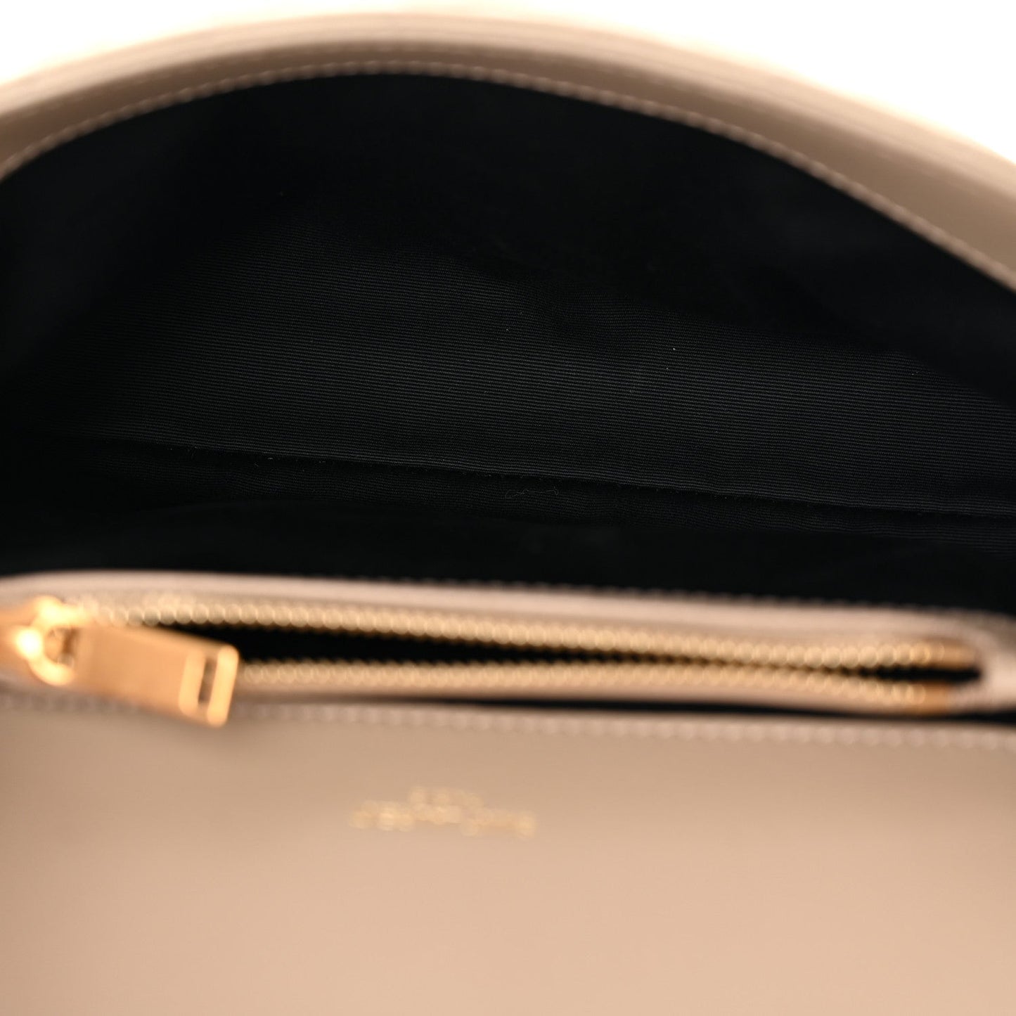Suede bag interior with black lining and gold zipper pull