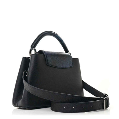 Black leather handbag with top handle, front pocket, and adjustable crossbody strap