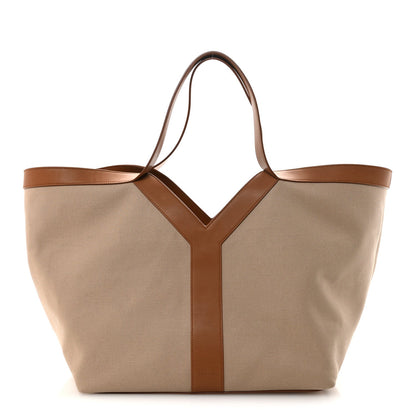 Tan canvas tote with brown leather trim and Y-shaped front panel, top handles