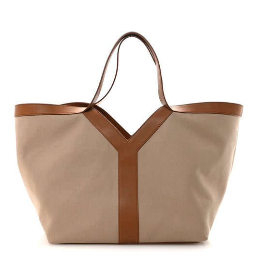 Tan canvas tote with brown leather trim and Y-shaped front panel, top handles