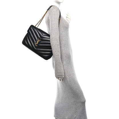 Black quilted shoulder bag on gold chain strap with YSL emblem