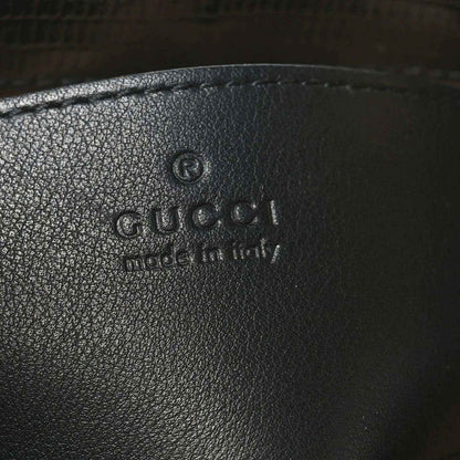 Gucci logo embossed on black leather handbag interior lining.