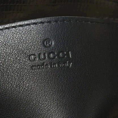 Gucci logo embossed on black leather handbag interior lining.