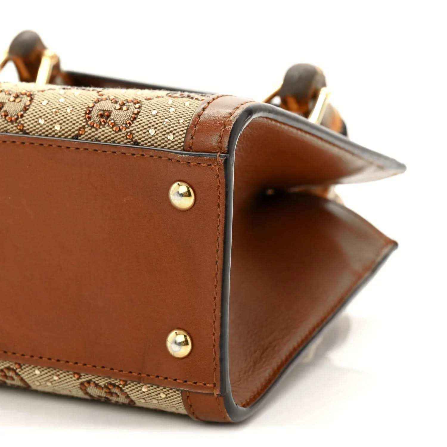 Gucci mini tote bag corner close-up with gold-tone studs and brown leather trim.