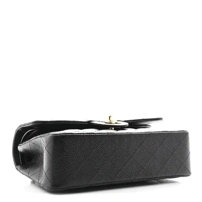 Chanel small double flap bag, black leather, side view with gold turn-lock hardware