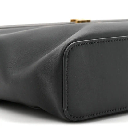 Black leather rectangle bag side corner with rounded panel and edge stitching