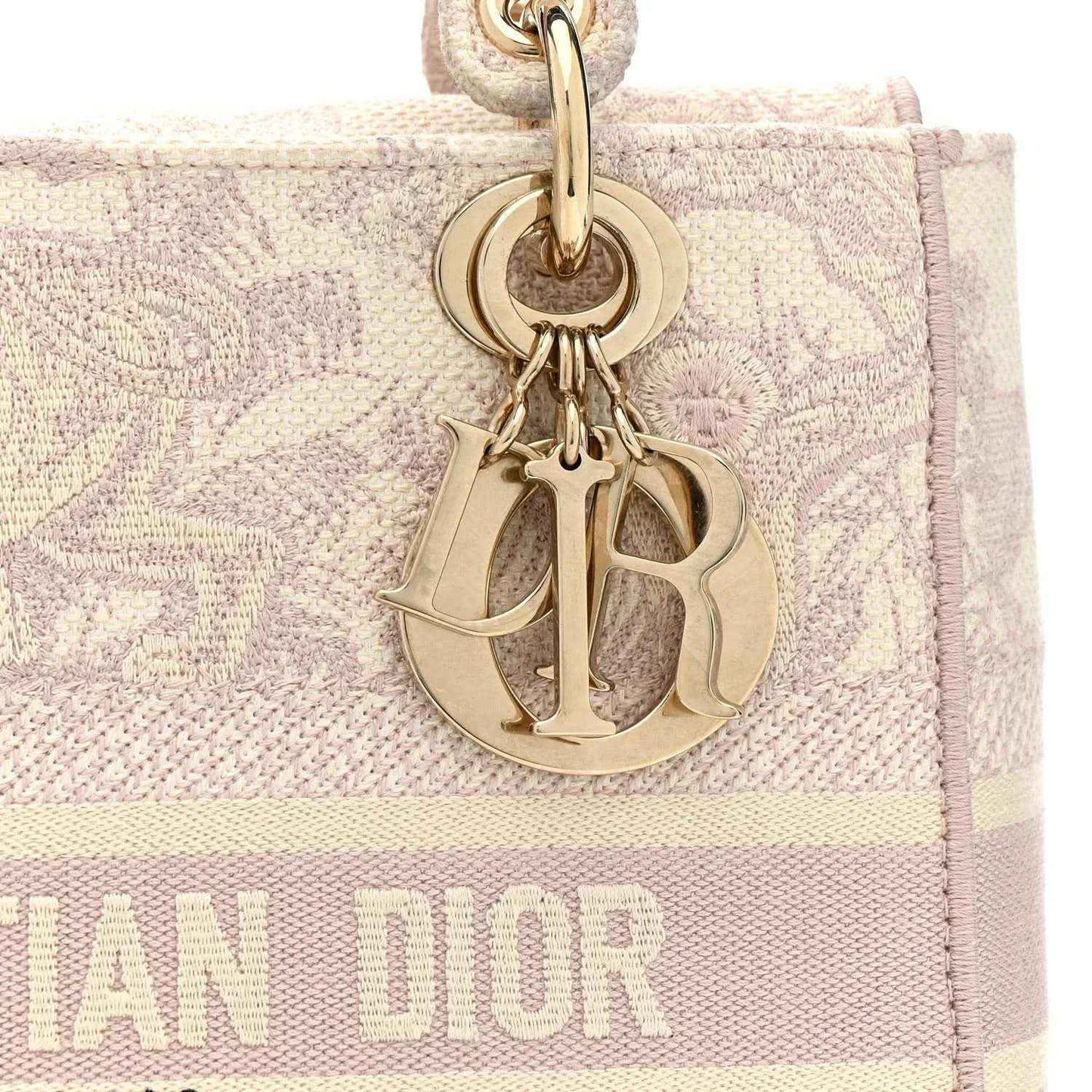 Rose-pink embroidered handbag with gold Dior-style logo charm and textured strap attachment