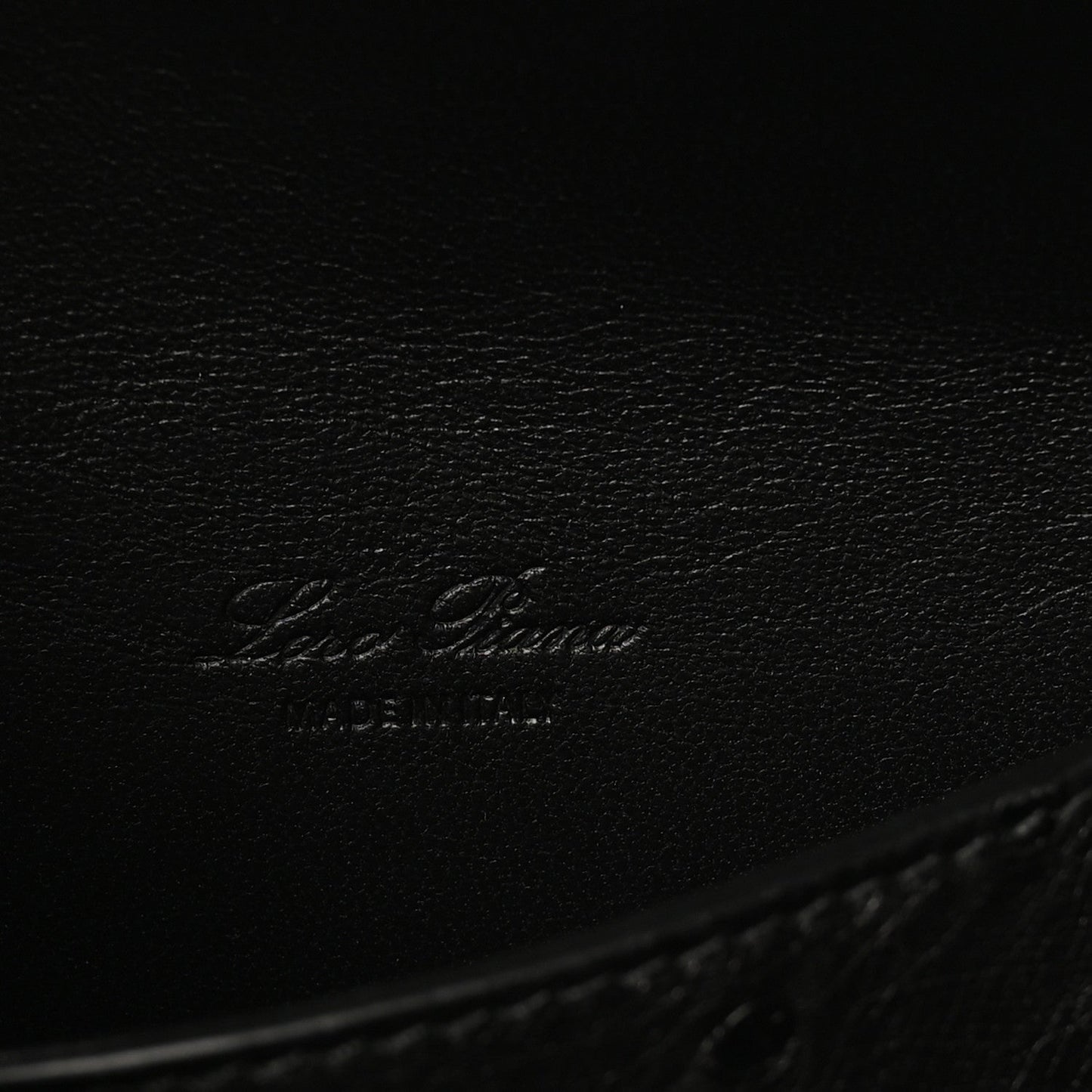 Black ostrich leather with embossed Loro Piana logo on inner base.