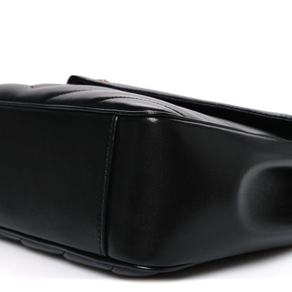 Black quilted leather shoulder bag, side view with top handle and stitching