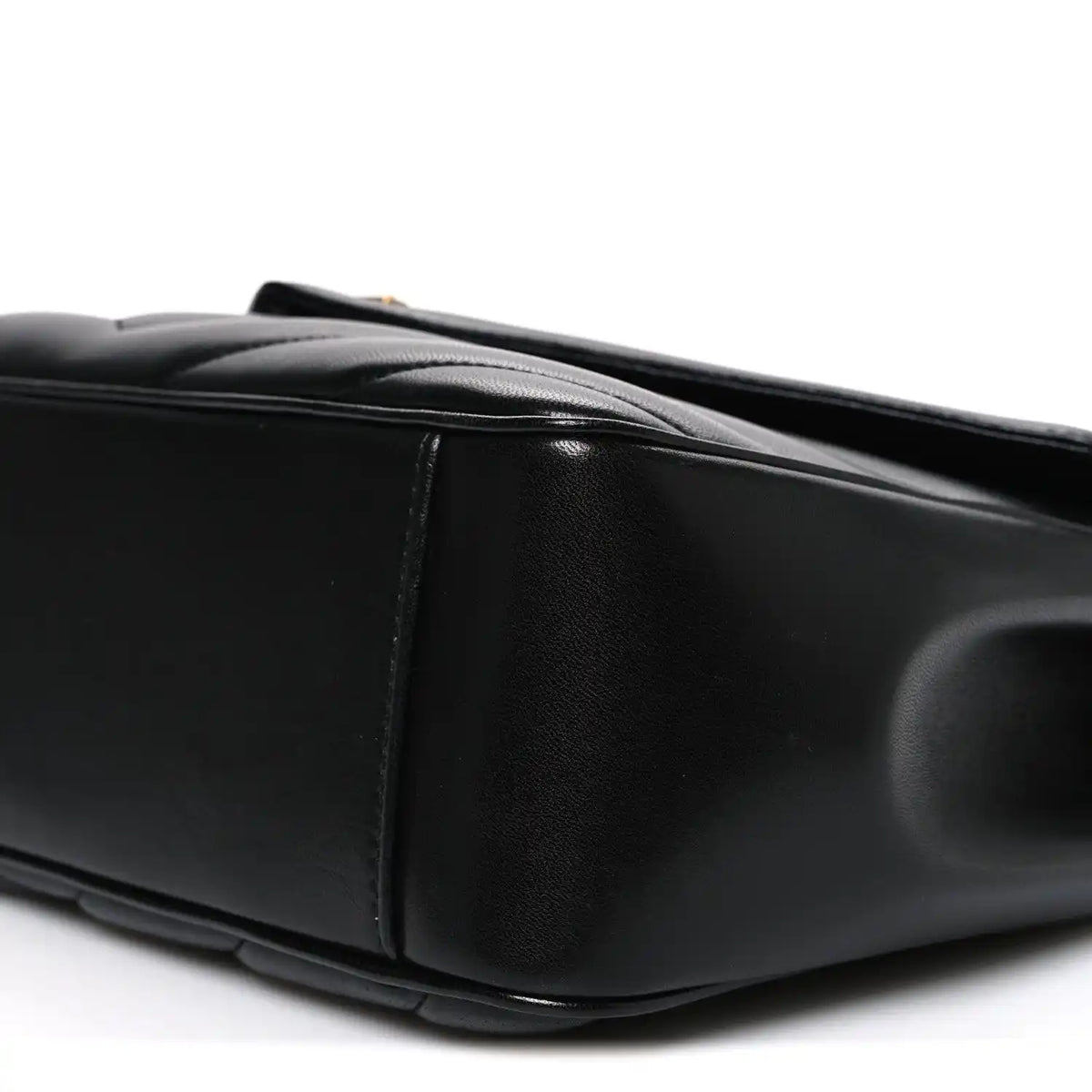 Black quilted leather shoulder bag, side view with top handle and stitching