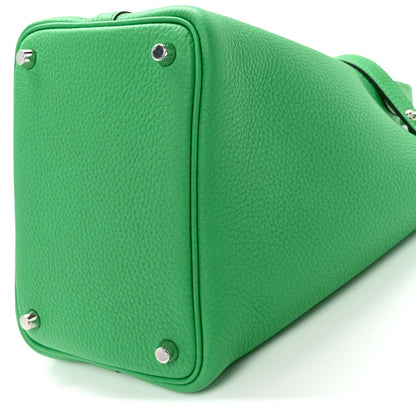 Green leather lock tote bag with structured sides and metal corner studs