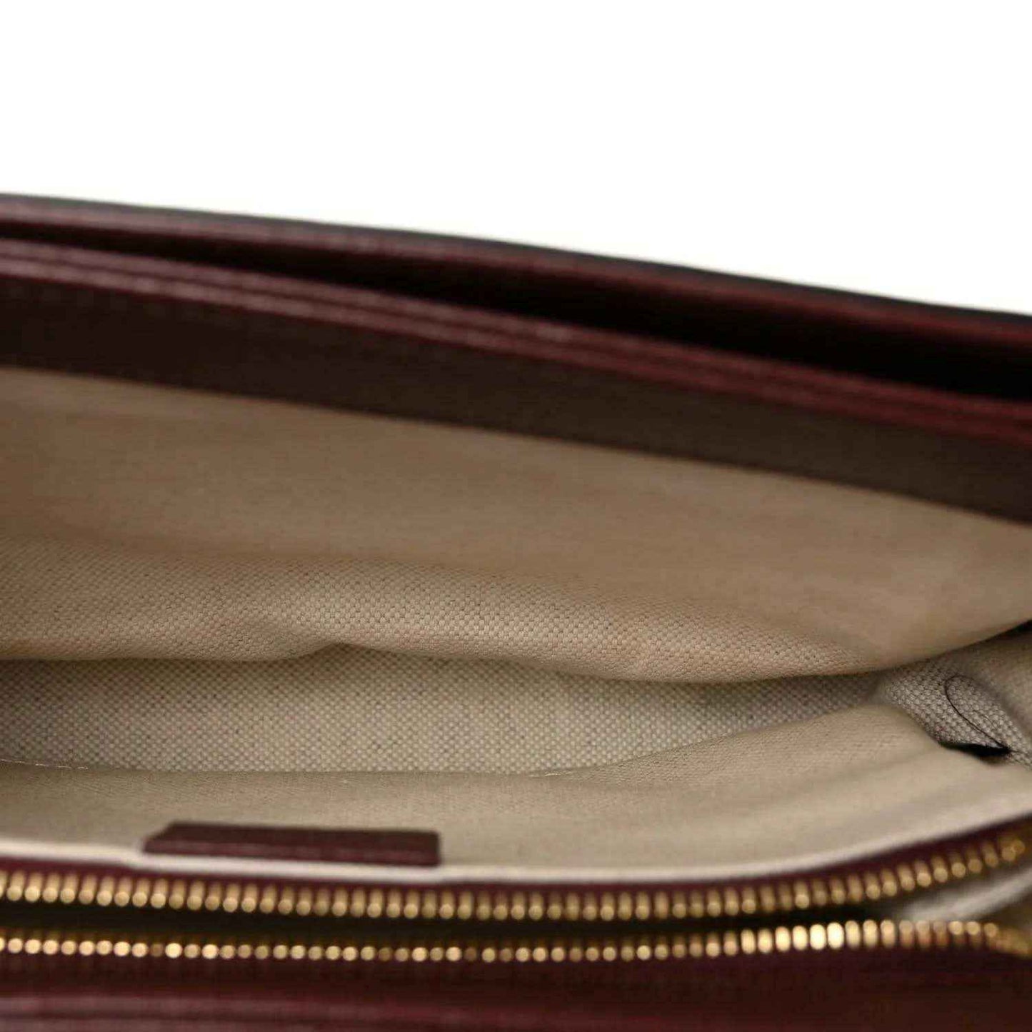 Gucci shoulder bag interior view with beige fabric lining and gold-tone zipper detail
