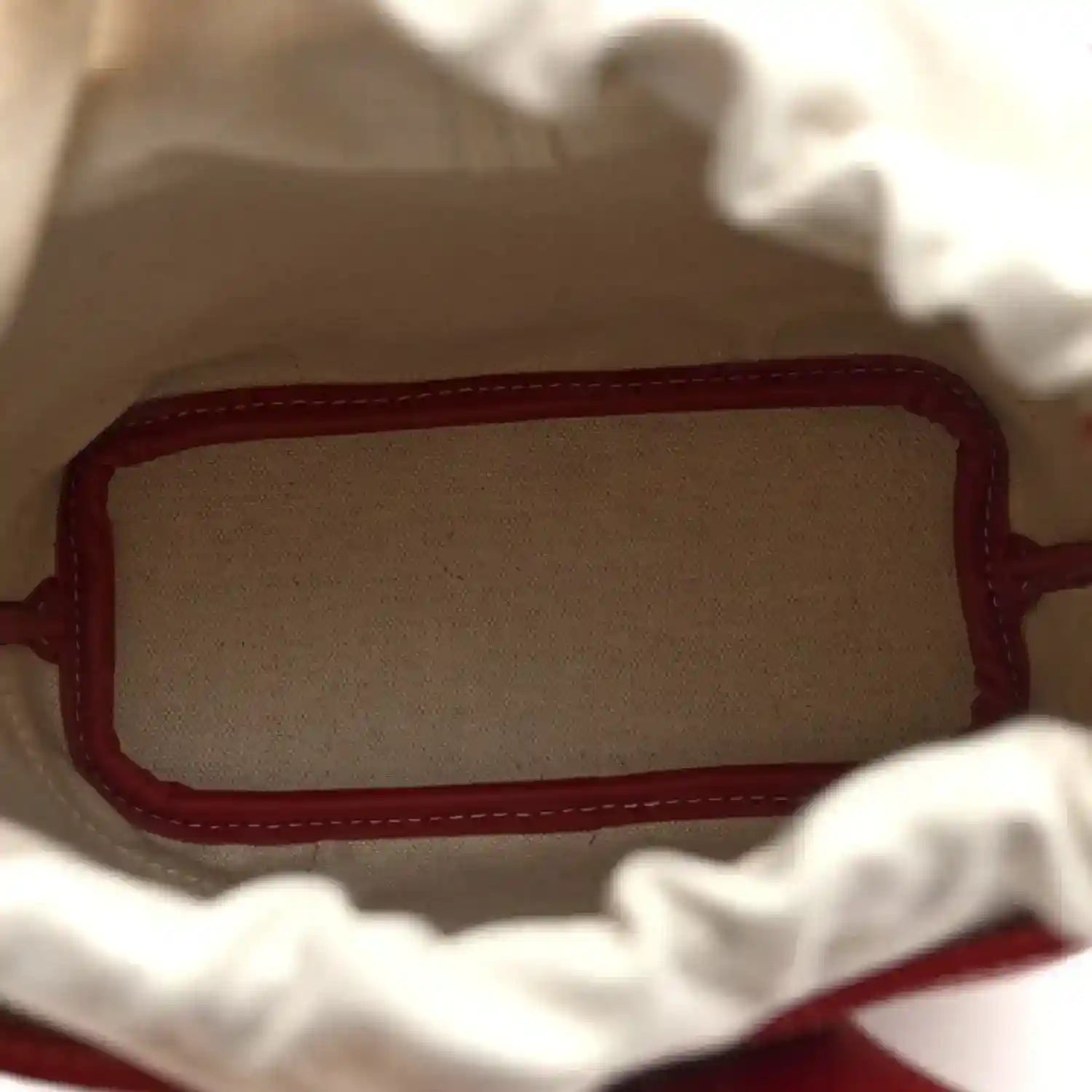 Red mini handbag interior with fabric lining and red leather trim at opening