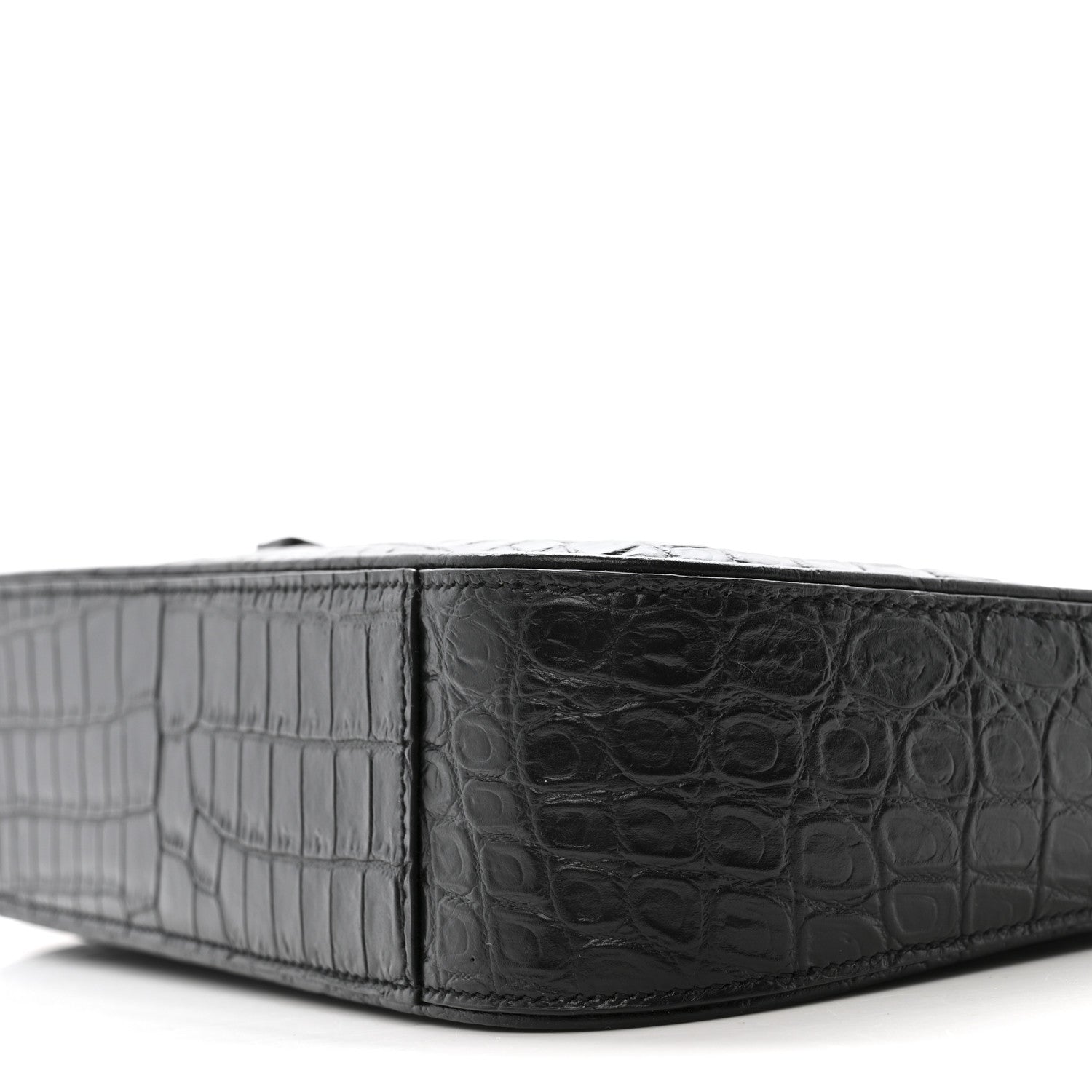 Close-up of crocodile-embossed bag base with panel detailing and edge trim.