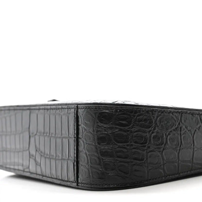 Close-up of crocodile-embossed bag base with panel detailing and edge trim.
