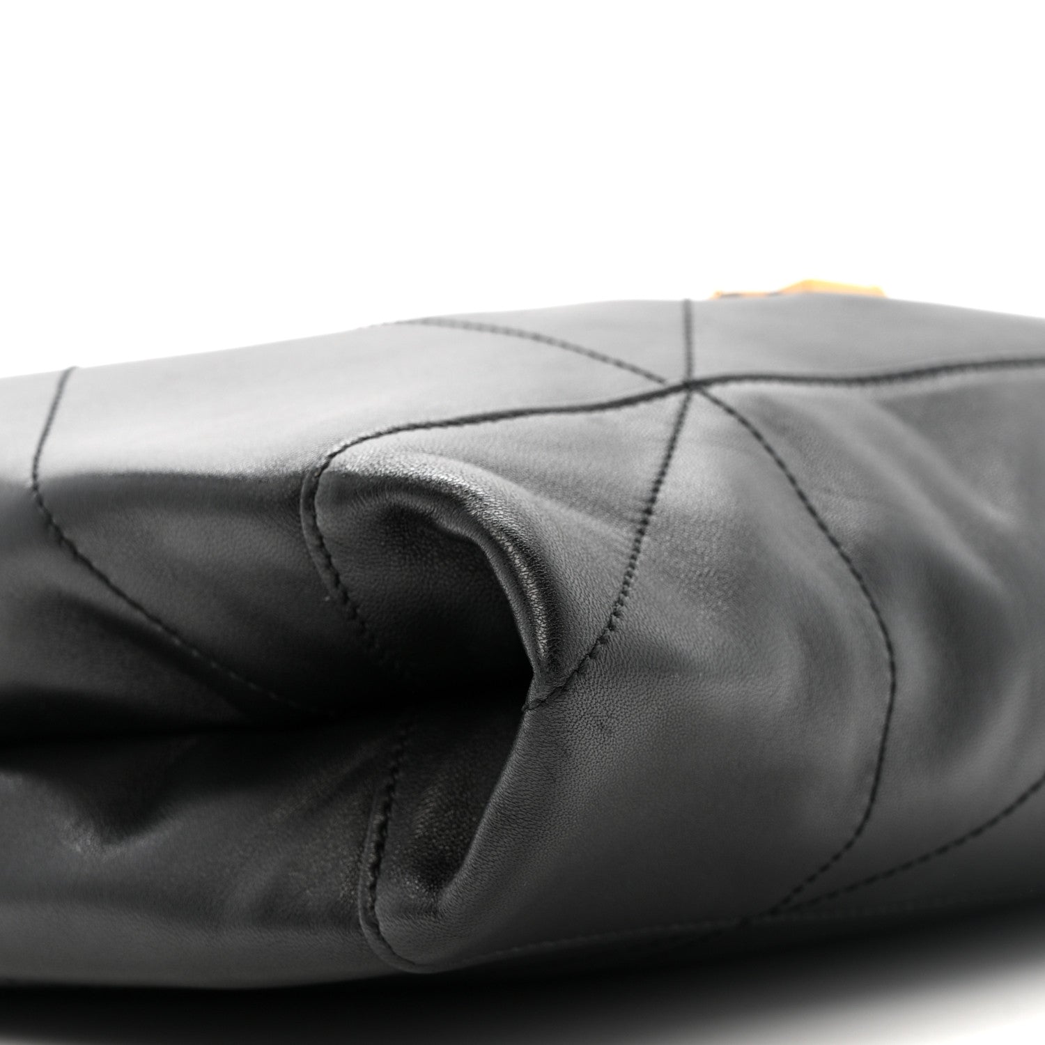 Black quilted leather drawstring bag with gathered top and stitched seams close-up