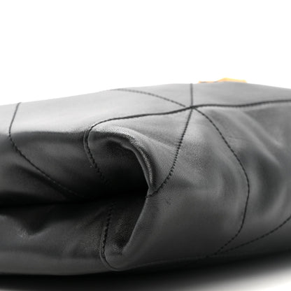 Black quilted leather drawstring bag with gathered top and stitched seams close-up
