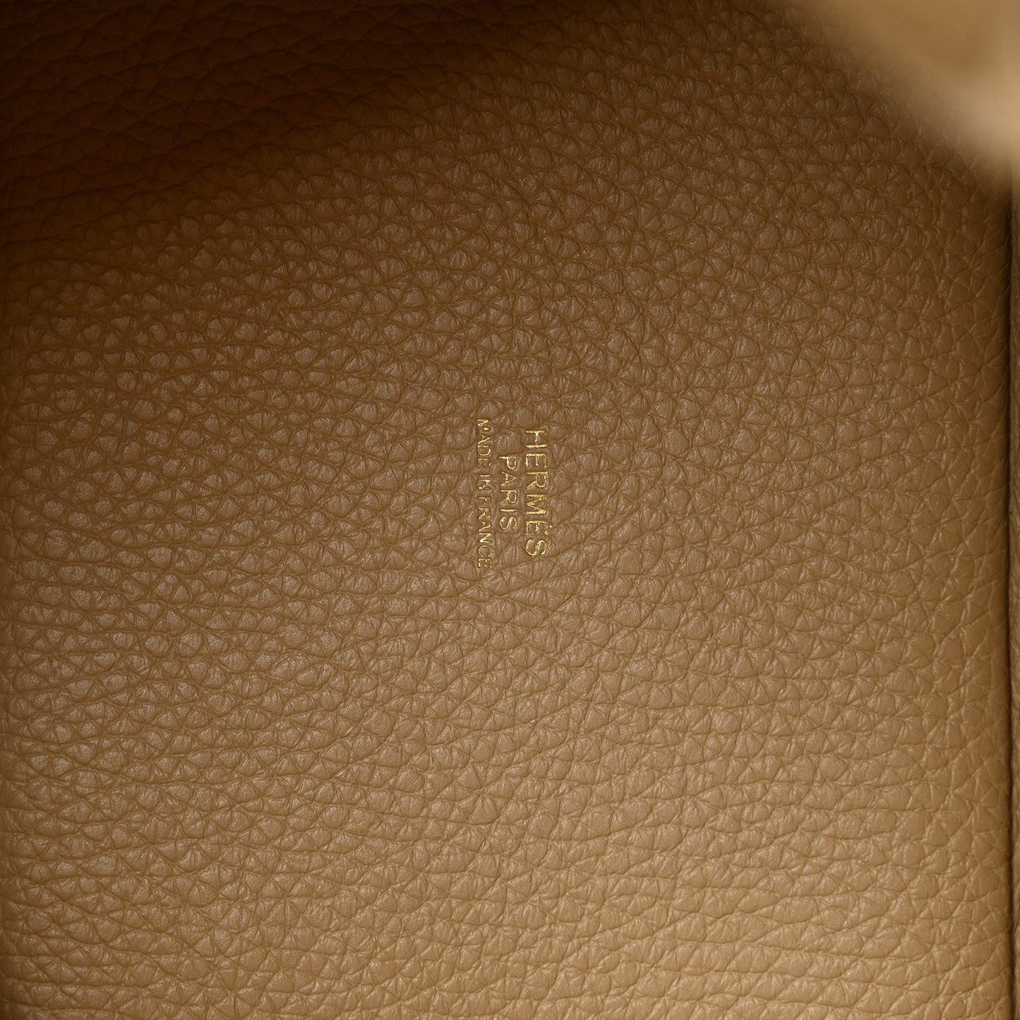 Beige grained leather lining with embossed HERMES logo on interior panel.