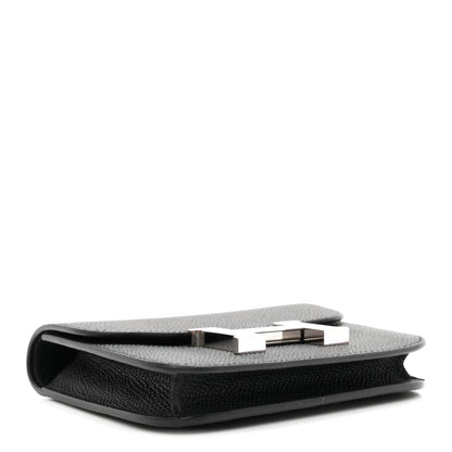 Black slim wallet side view with clasp bar and top edge seam.