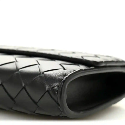 Black woven leather clutch with rounded end and top handle
