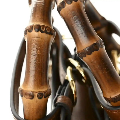 Bamboo handles detail on mini tote bag with carved accents and gold-tone hardware