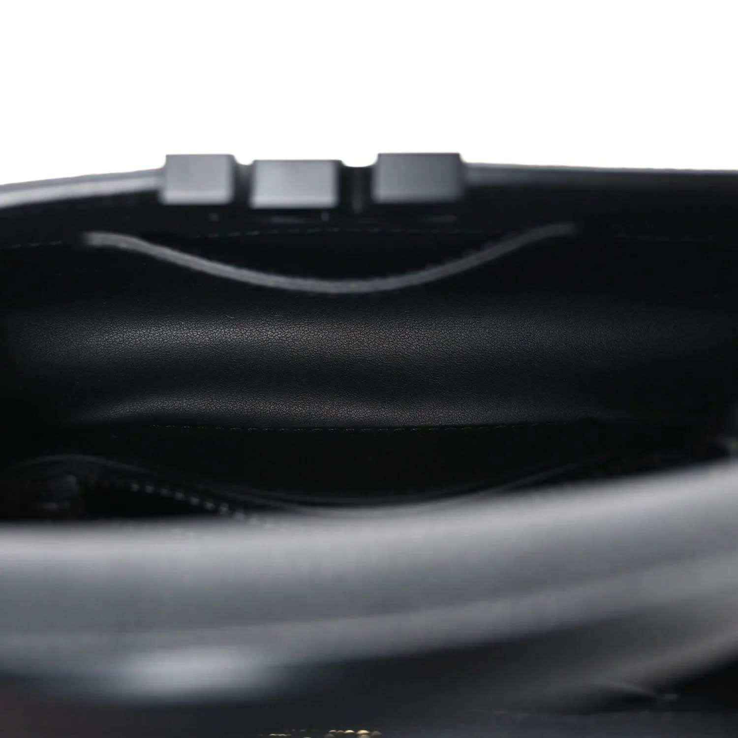 Mini black handbag interior with top opening and strap hardware.