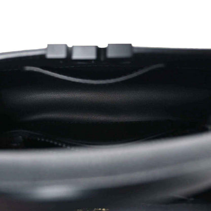Mini black handbag interior with top opening and strap hardware.