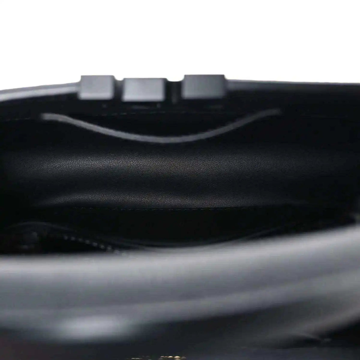 Mini black handbag interior with top opening and strap hardware.