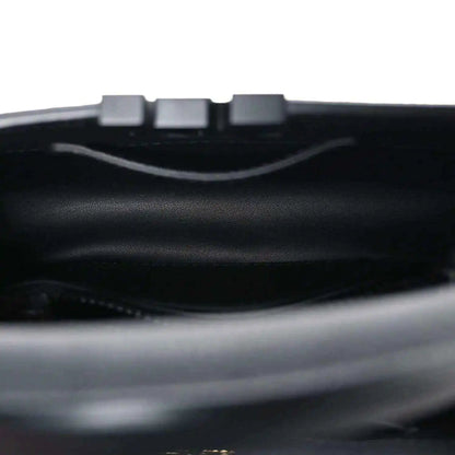 Mini black handbag interior with top opening and strap hardware.