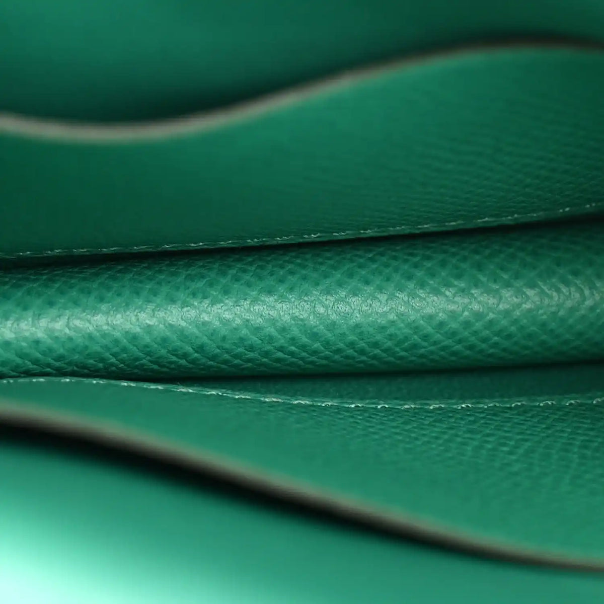 Green leather seam and edge stitching detail with textured grain