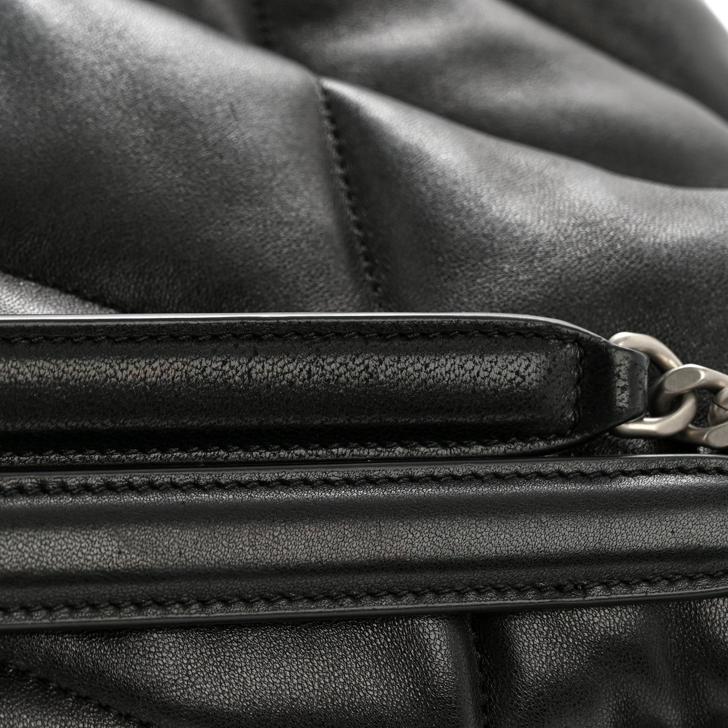Black quilted lambskin satchel with zipper closure and stitched edges