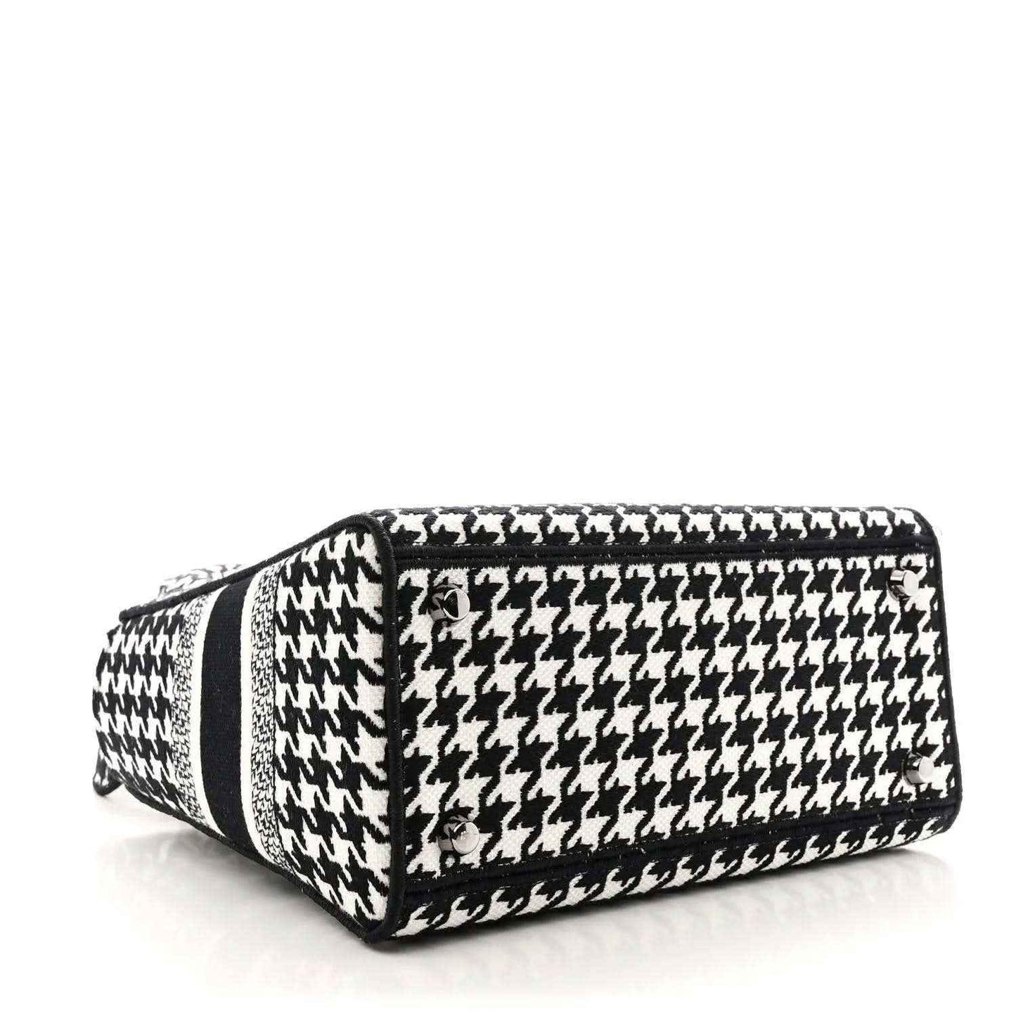 Black-and-white houndstooth canvas duffel-style bag with black trim and top handle