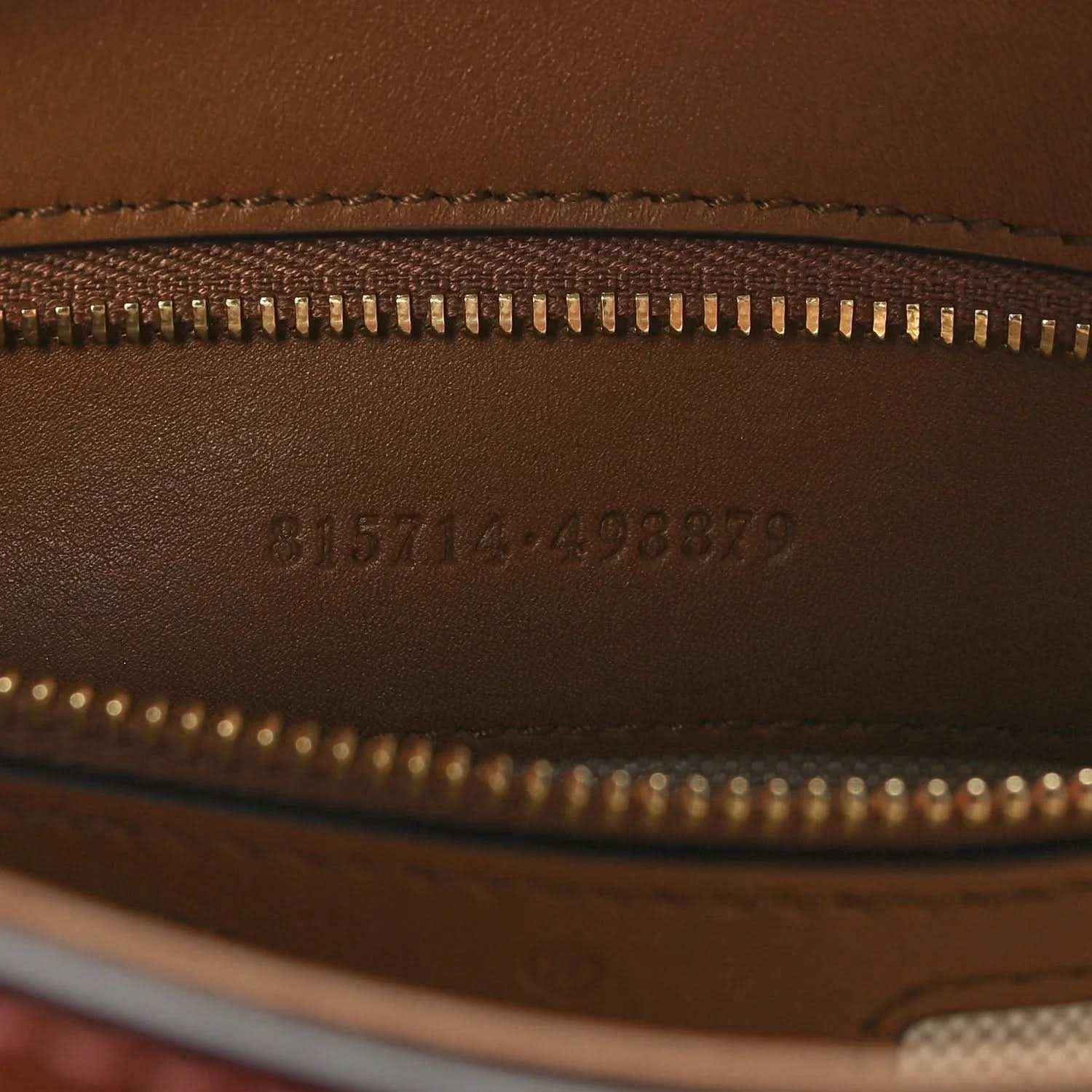 Brown leather exterior with gold zipper and embossed serial code