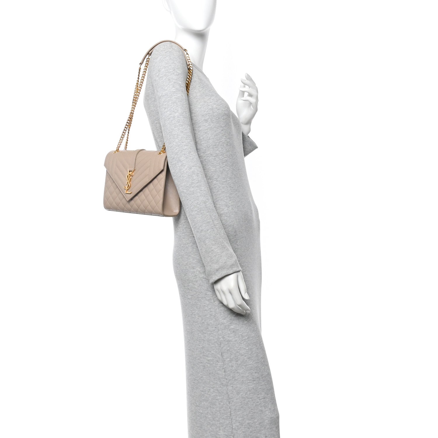 Quilted shoulder satchel bag with gold-tone chain strap, shown worn on a model in dark beige.