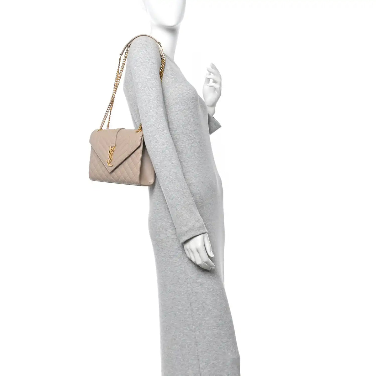 Quilted shoulder satchel bag with gold-tone chain strap, shown worn on a model in dark beige.
