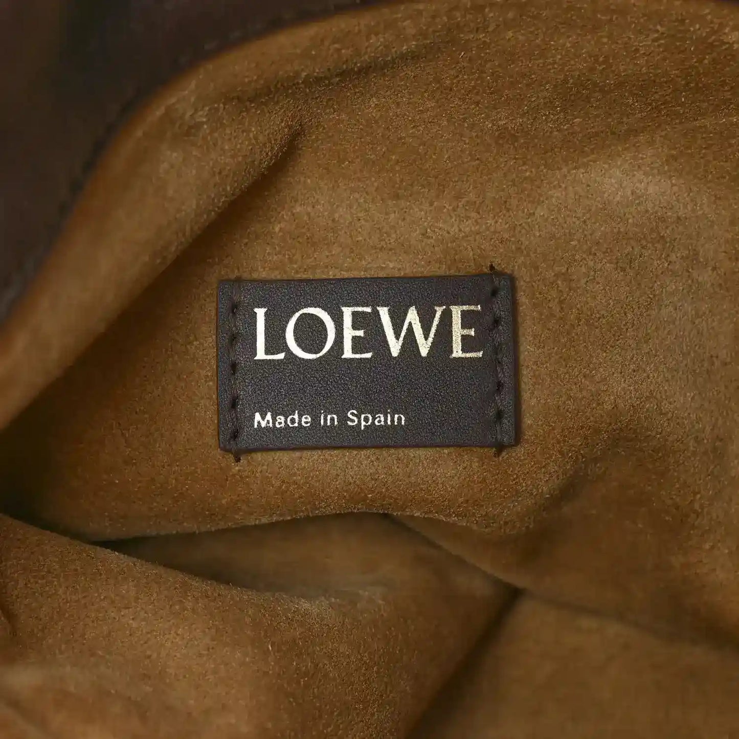 Tan suede-like interior lining with Loewe label reading “Made in Spain”.